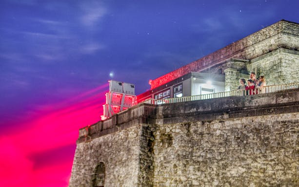 Family observing lights at Illumination Tower, Niagara Falls evening tour.