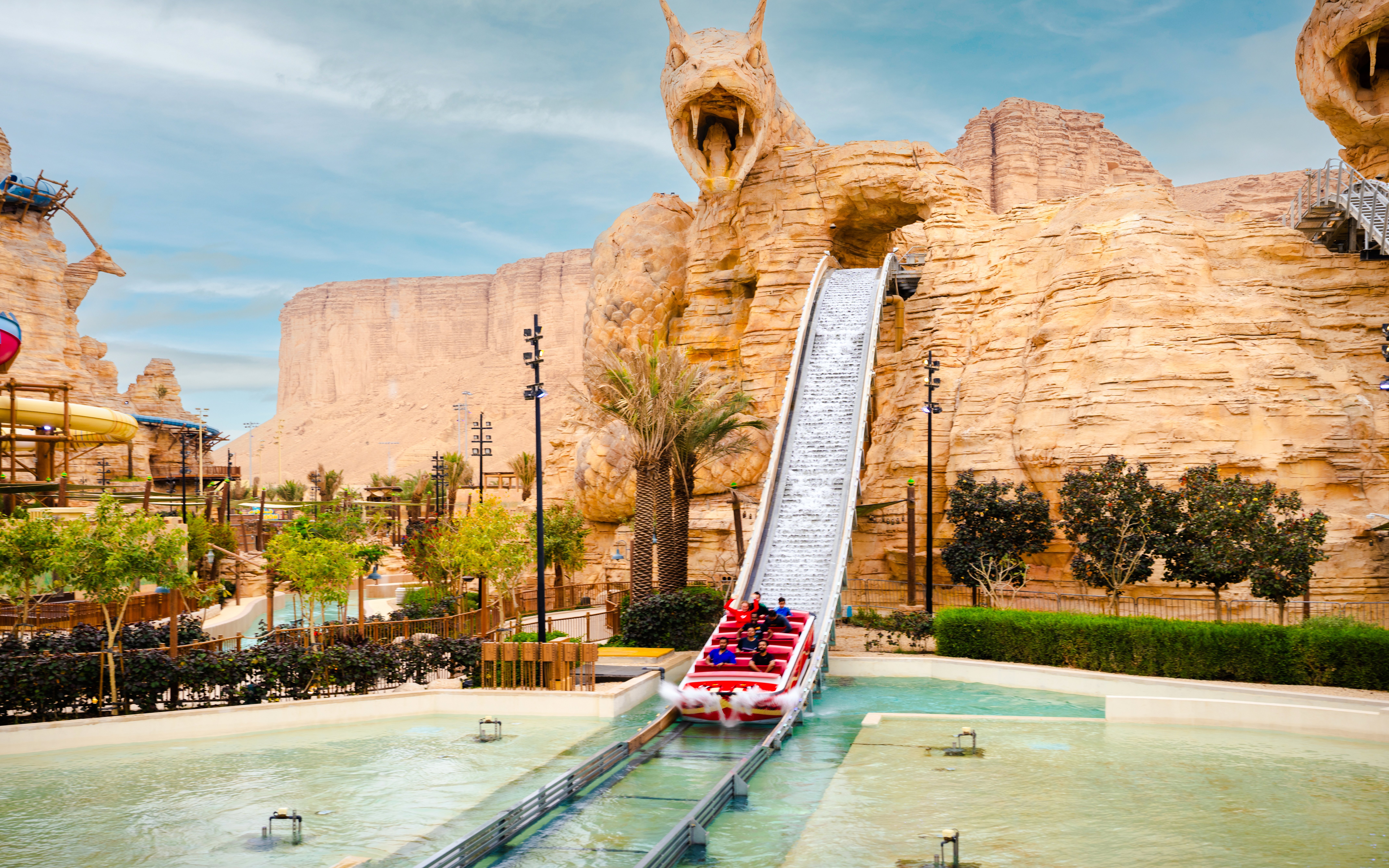 Water ride descending from dragon-themed structure at Aquarabia Qiddiya.