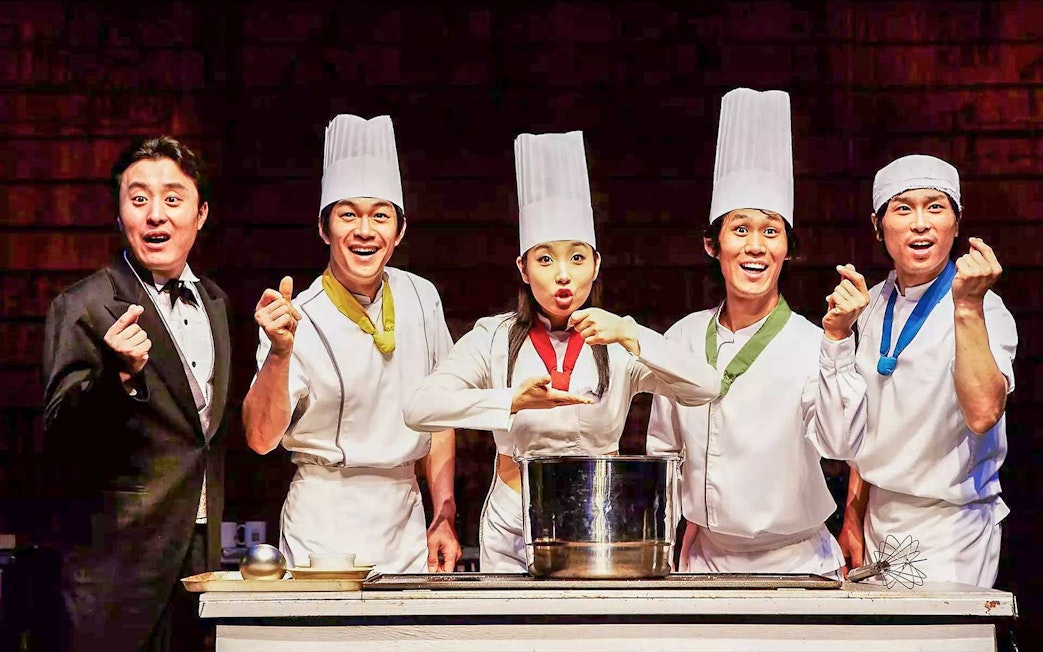 Performers in chef outfits on stage at Seoul Myeongdong Nanta Musical Show.