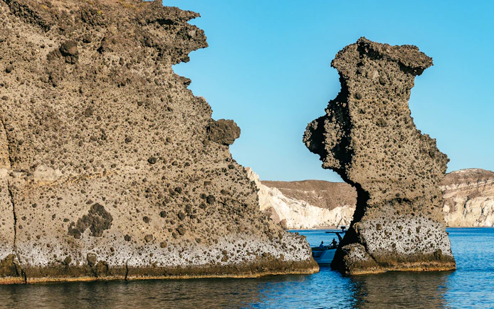 Rock formations with a boat near Indian Rock, Santorini.