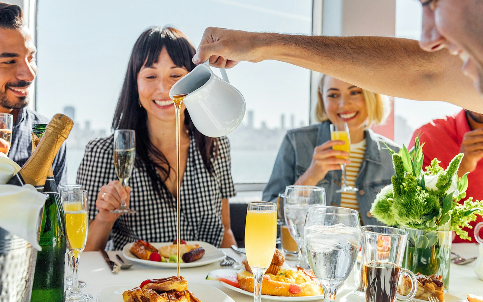 Guests enjoying brunch with mimosas on a New York Signature Dinner Cruise.