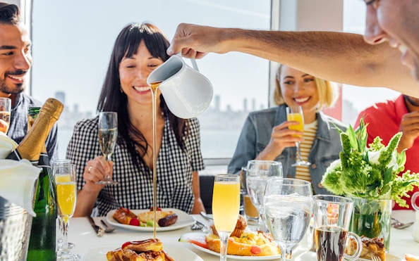 Guests enjoying brunch with mimosas on a New York Signature Dinner Cruise.