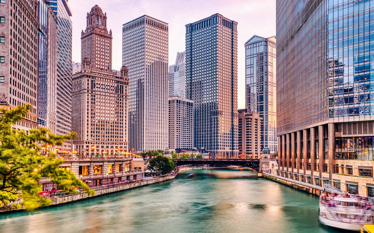 Chicago River with skyscrapers at sunset during architecture cruise.