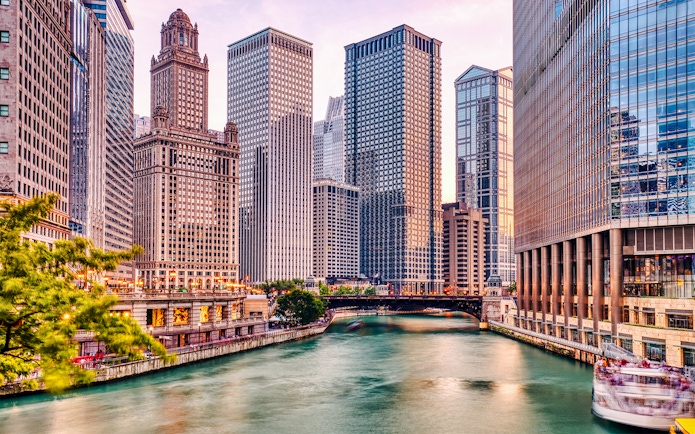 Chicago River with skyscrapers at sunset during architecture cruise.