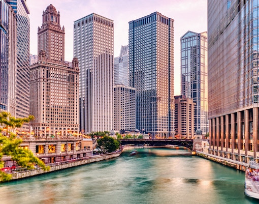 Chicago River with skyscrapers at sunset during architecture cruise.