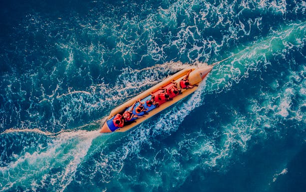 People enjoying a banana boat ride on the ocean.