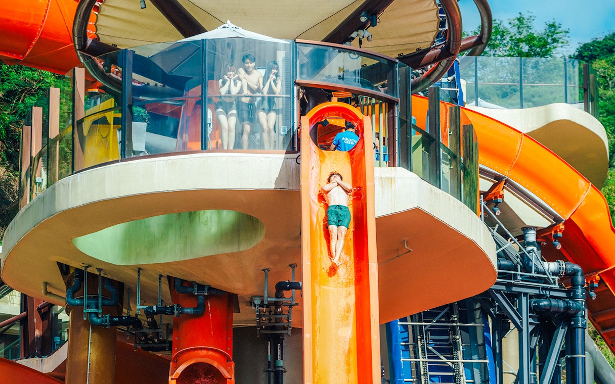 Person sliding down orange waterslide at Water World Ocean Park, Hong Kong.