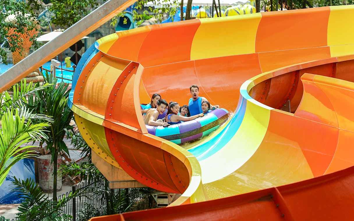 Group enjoying a colorful water ride at Sunway Lagoon theme park.