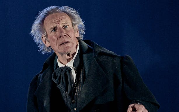 Actor in period costume performing "A Christmas Carol - A Ghost Story" on stage.