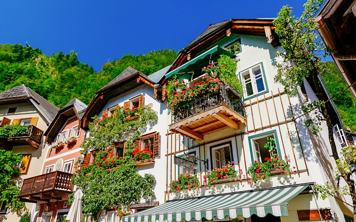 Colorful houses with flower-adorned balconies in Hallstatt, Austria, seen on a day trip from Vienna.
