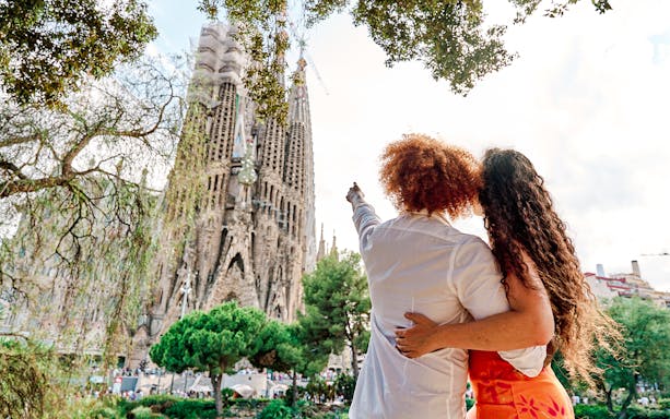 Tourists admiring the Sagrada Familia in Barcelona during summer.