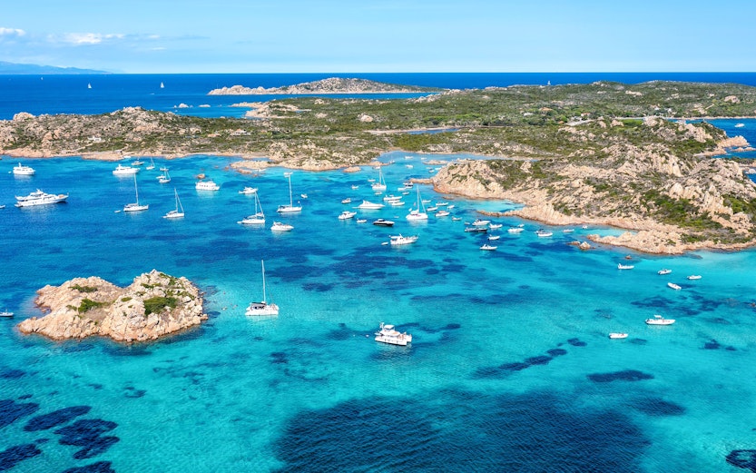 Boats anchored in the turquoise waters around La Maddalena, Sardinia.
