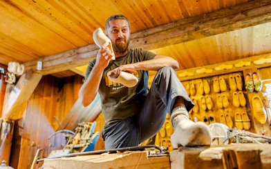 Clog maker demonstrating shoe crafting at Zaanse Schans workshop.