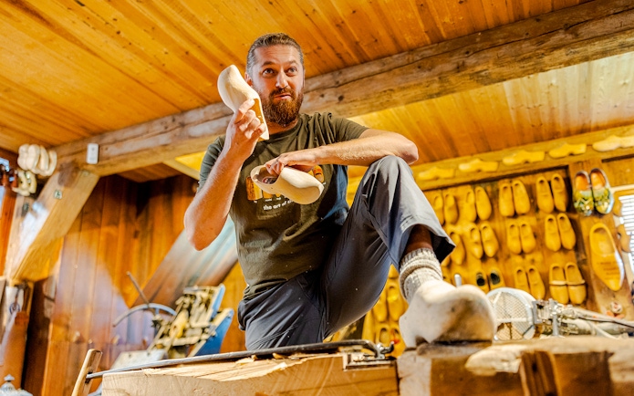Clog maker demonstrating shoe crafting at Zaanse Schans workshop.