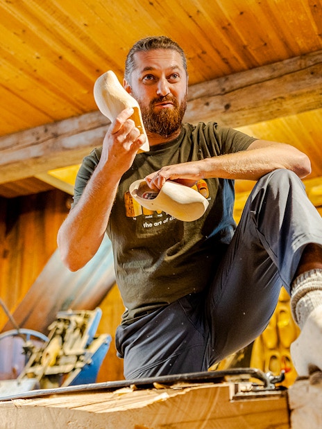 Clog maker demonstrating shoe crafting at Zaanse Schans workshop.