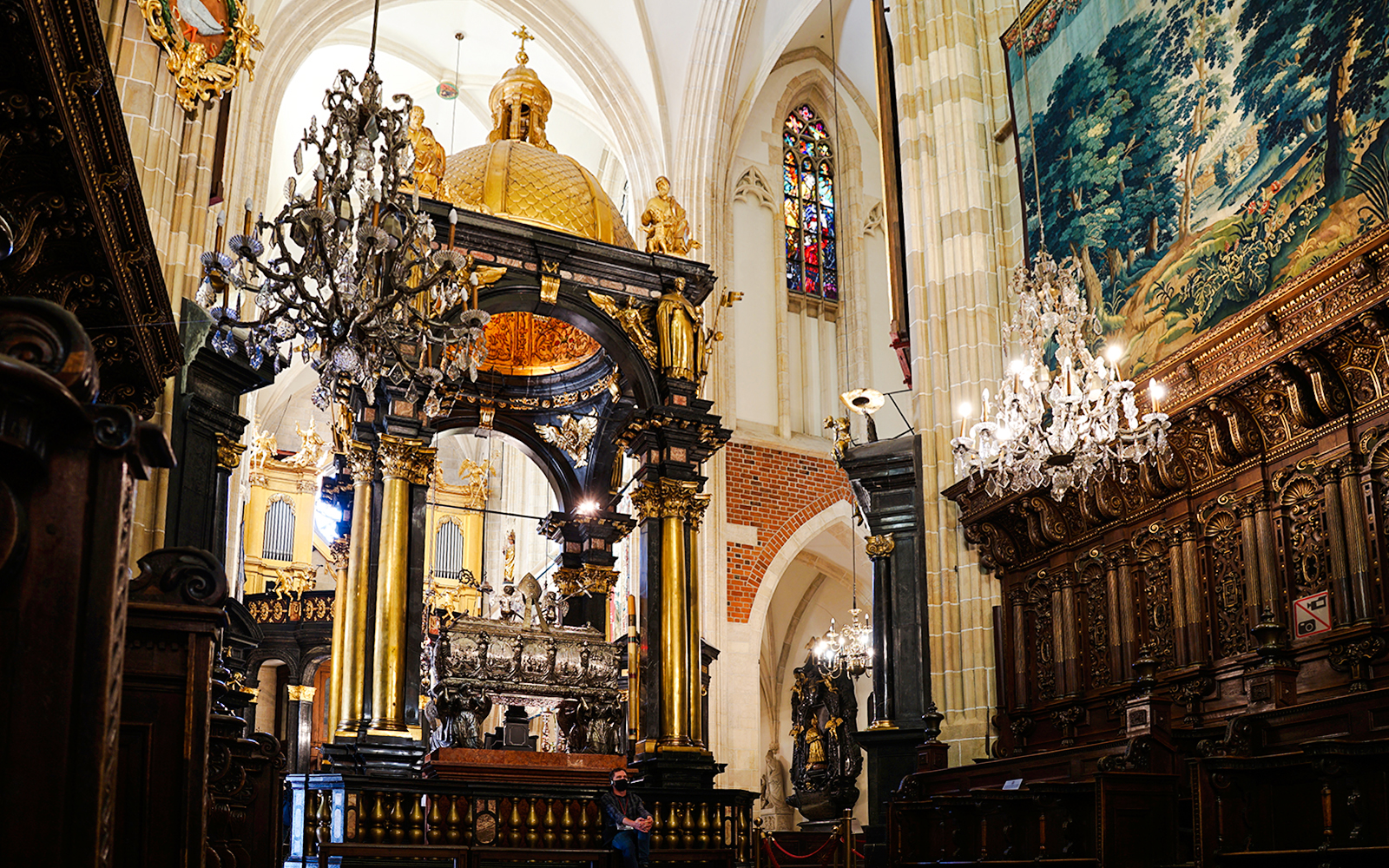 Interior of Wawel Cathedral with ornate chandeliers and detailed wood carvings.