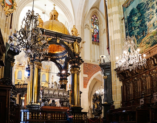 Interior of Wawel Cathedral with ornate chandeliers and detailed wood carvings.