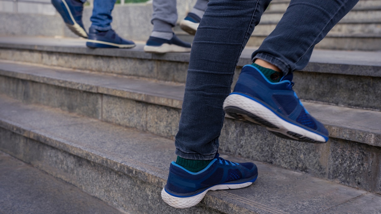 People ascending stone steps wearing casual shoes.
