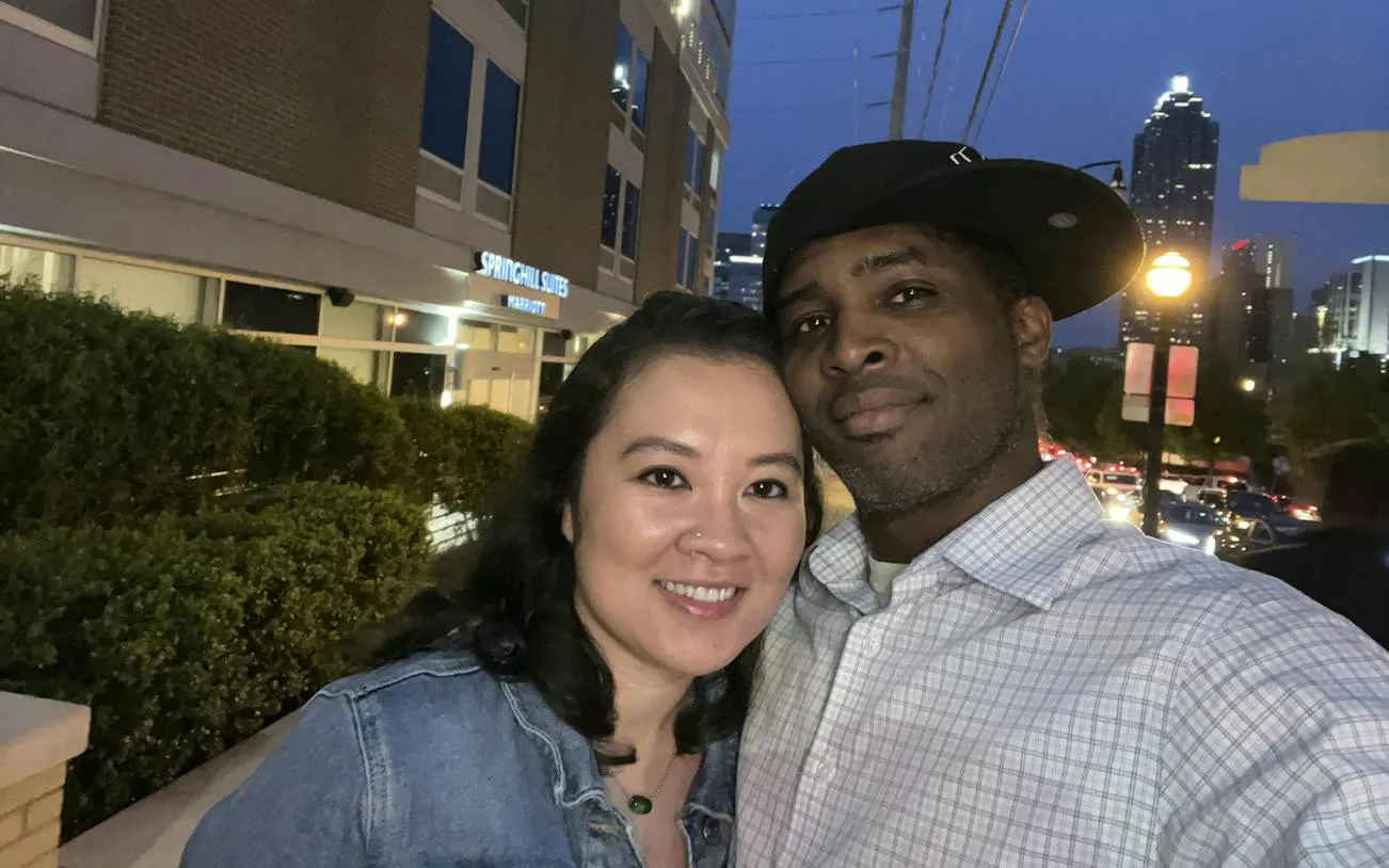 Couple enjoying evening in downtown Atlanta with city skyline in the background.
