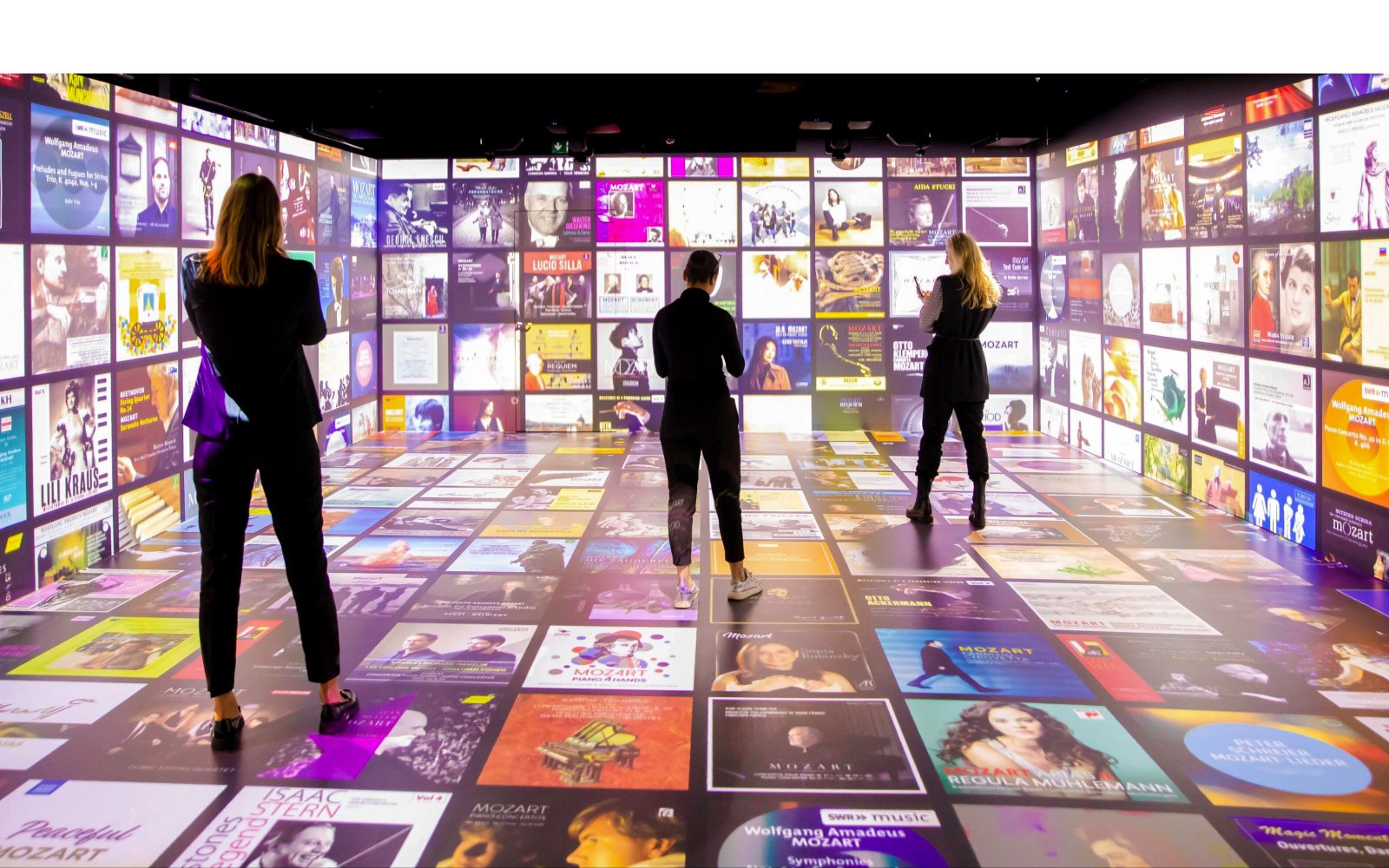 Guests explore digital displays at Mythos Mozart Immersive Experience in Vienna.