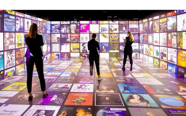 Guests explore digital displays at Mythos Mozart Immersive Experience in Vienna.