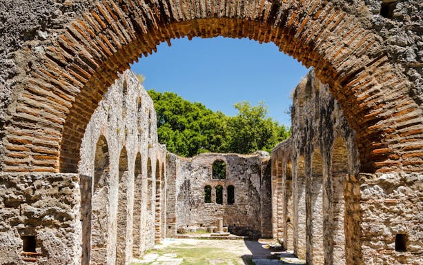 Ancient stone arches and walls of Butrint ruins in Albania.
