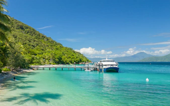 Ferry docked at Fitzroy Island with lush greenery and clear blue water.