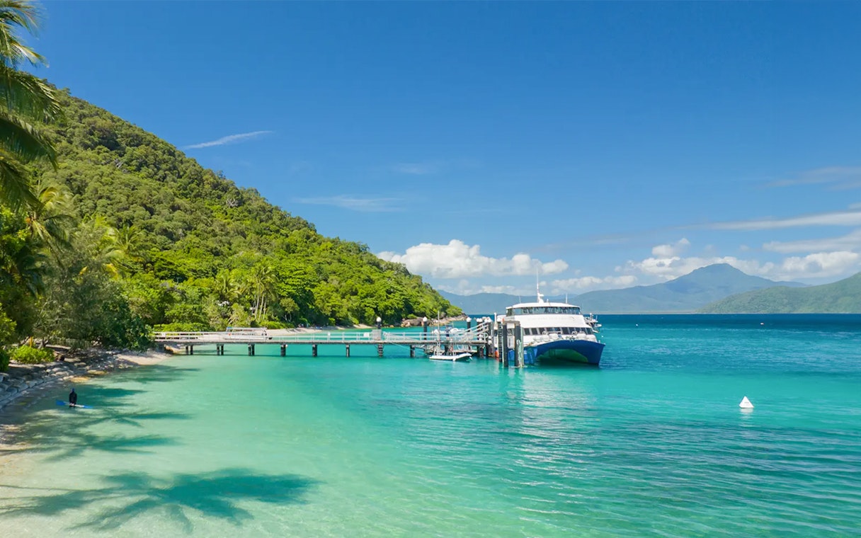 Ferry docked at Fitzroy Island with lush greenery and clear blue water.