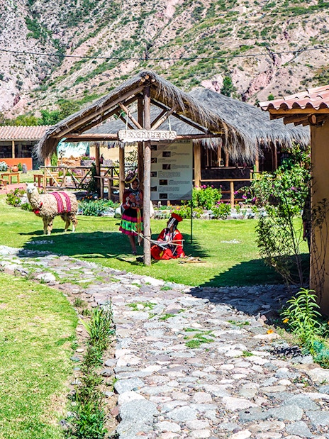 Yucay Museo de Cultura Viva entrance with traditional textiles and alpaca in Sacred Valley, Peru.