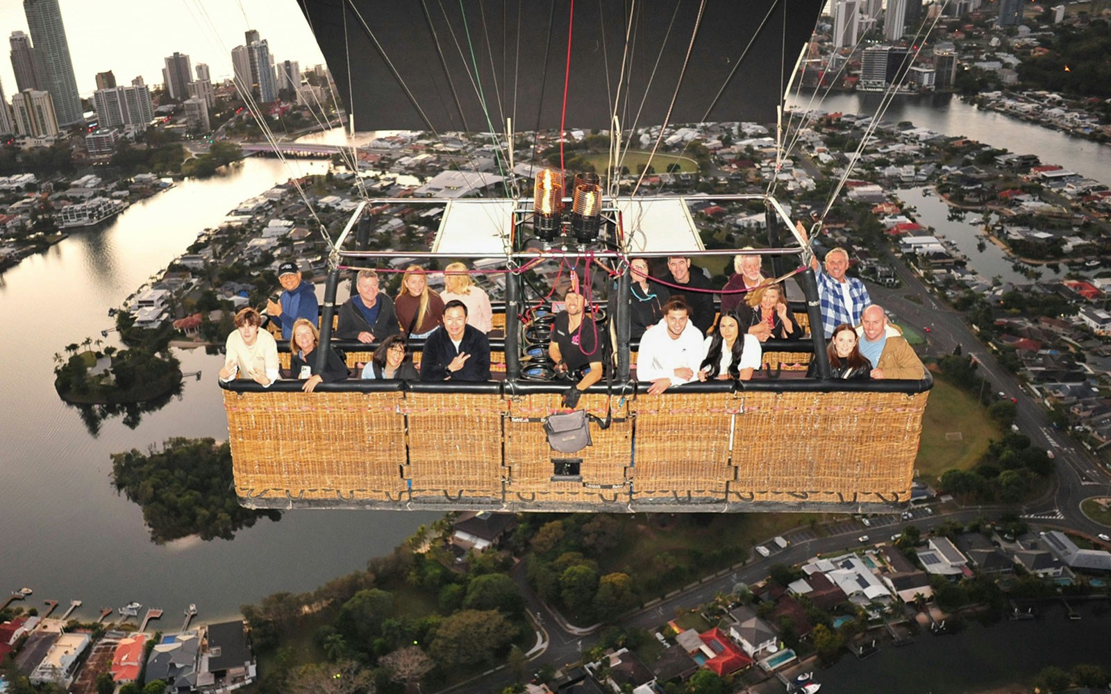 Group enjoying hot air balloon flight over cityscape with optional transfers.