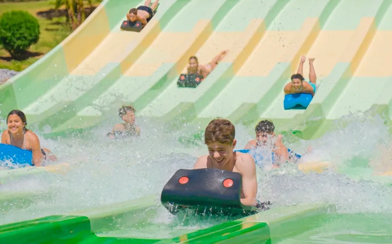 Water slide racers at Aqualand Torremolinos, Spain, enjoying the Kukulkan attraction.