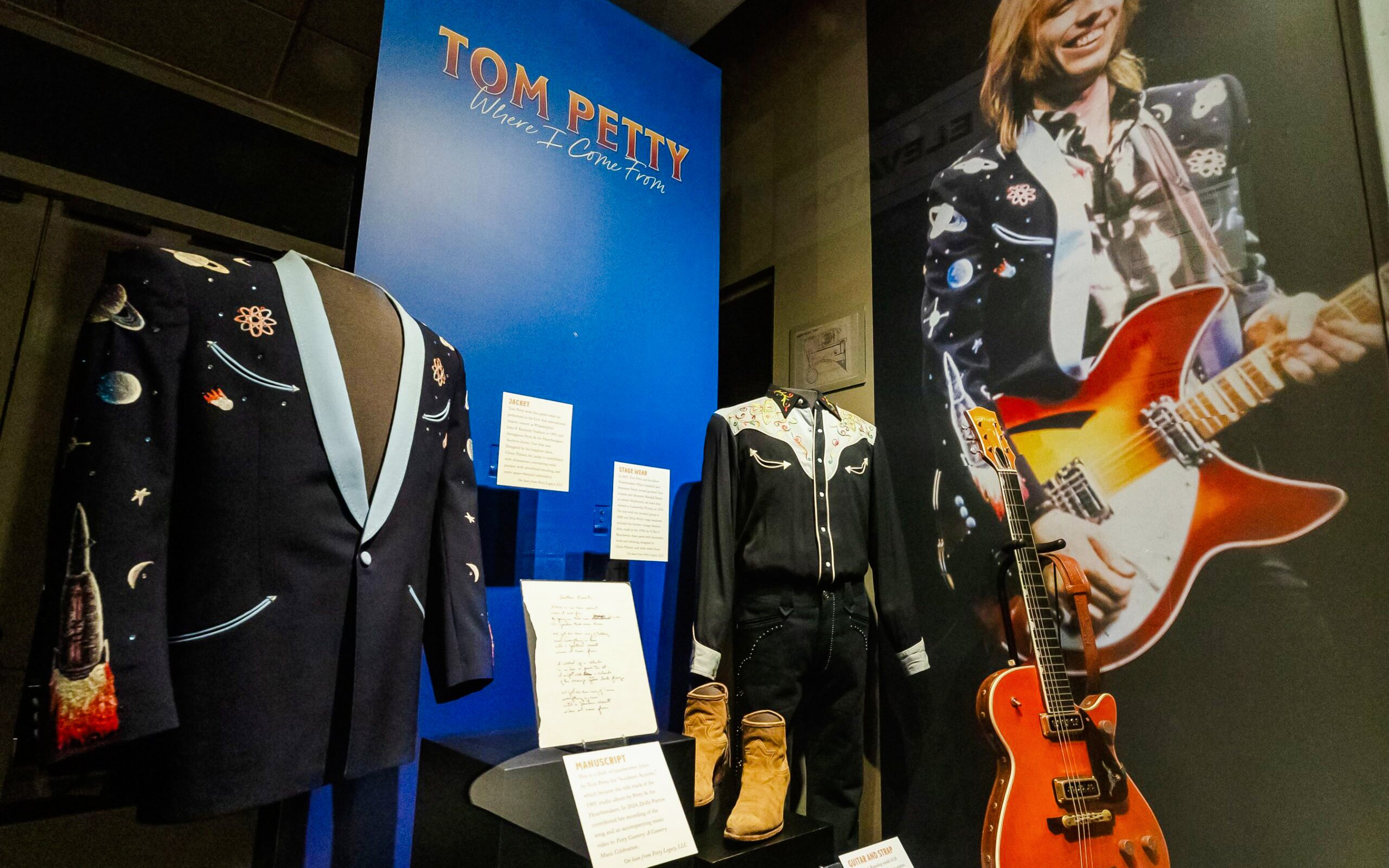 Tom Petty exhibit with stage outfits and guitar at Country Music Hall of Fame.