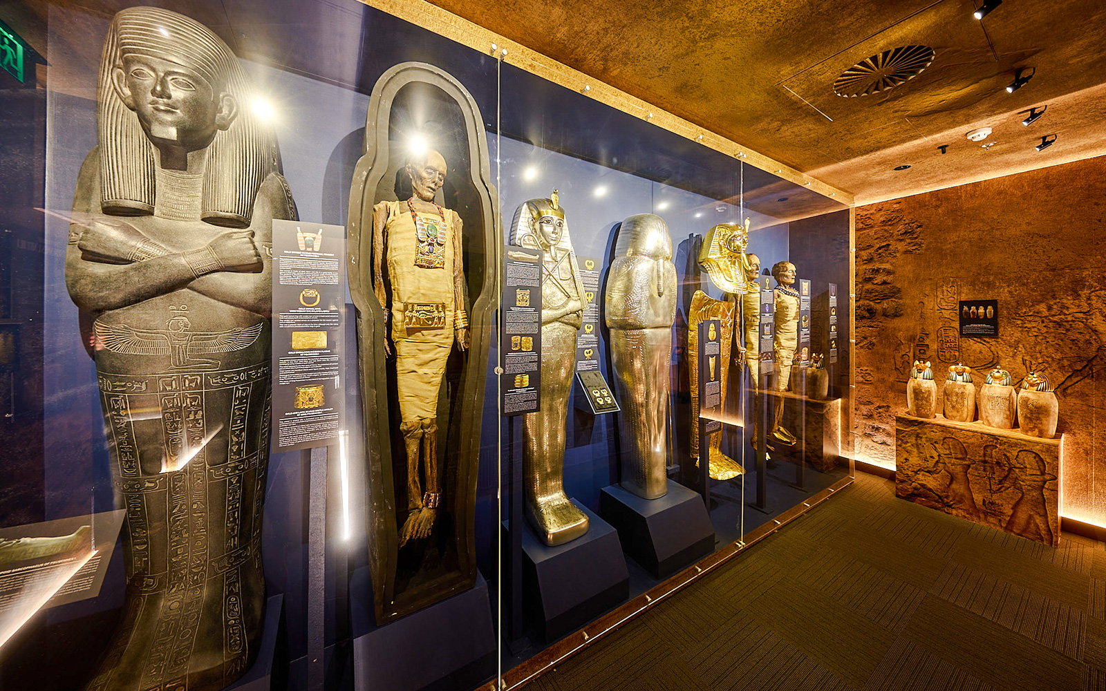 Ancient Egyptian sarcophagi and mummy cases in the Tomb of the Pharaoh exhibit.