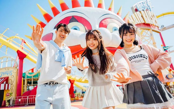 Friends posing in front of a colorful clown face at Ocean Park.