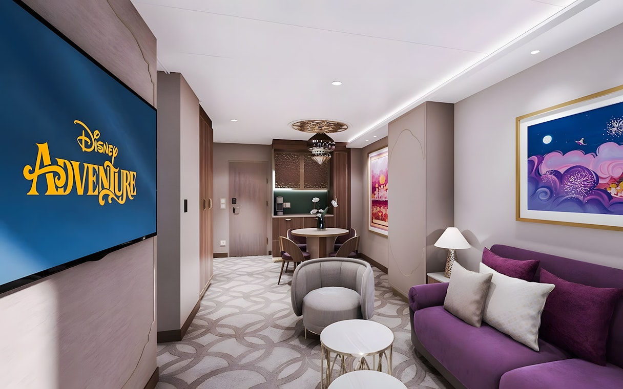 Concierge Family Oceanview Suite living area on Disney Adventure Cruise with seating and decor.
