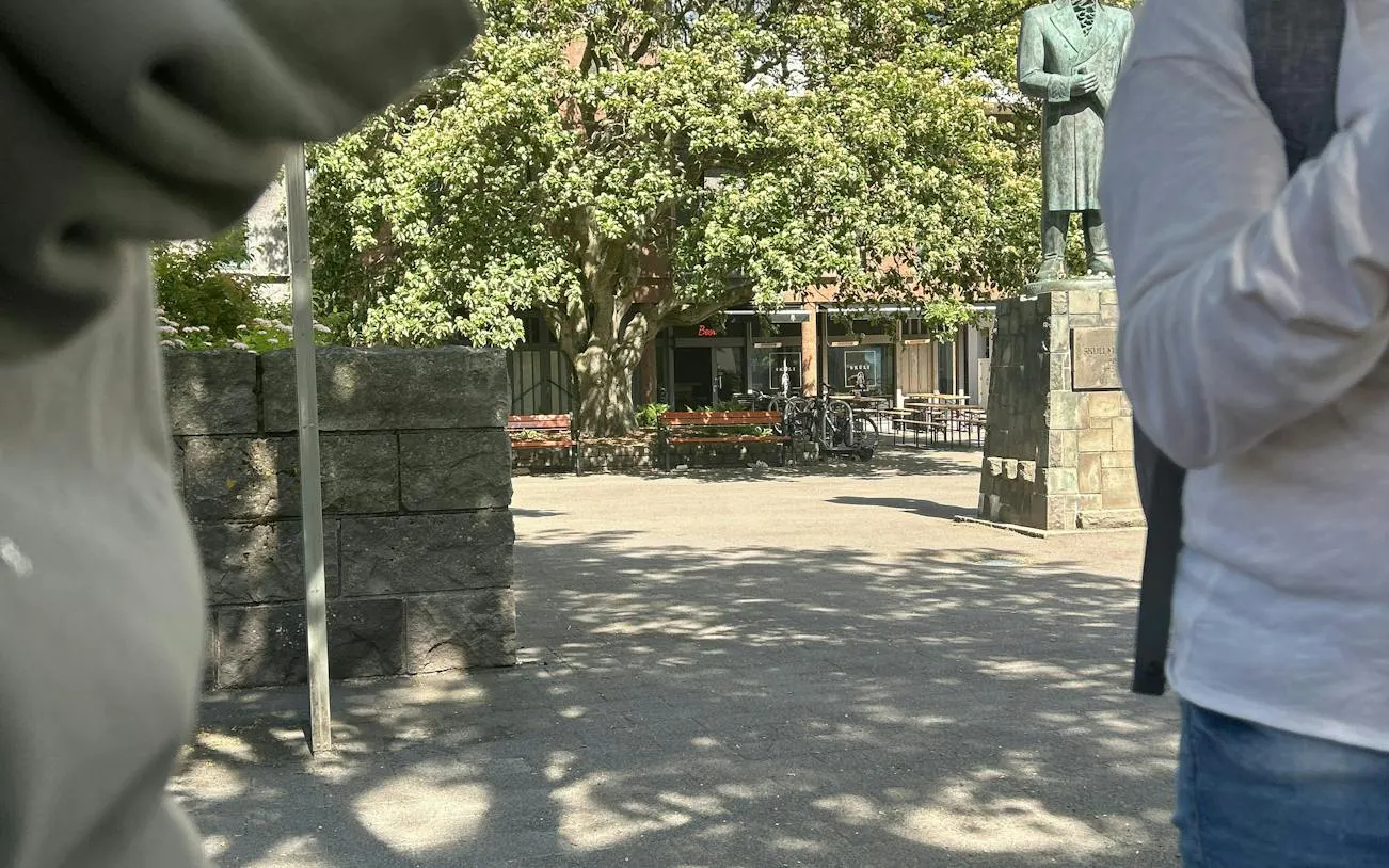 Statue in a sunny Reykjavik square with trees and benches, part of the self-guided city exploration game.