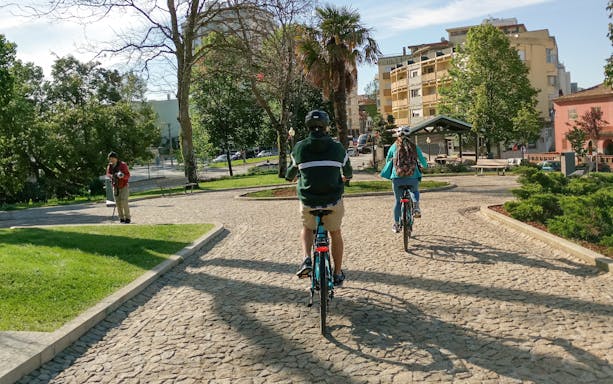 Cyclists on an electric bike tour in a park in Porto, Portugal.