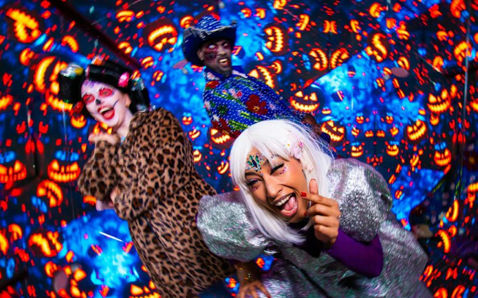Costumed people enjoying Halloween Twilight Spectacle with glowing jack-o'-lanterns in Hyperspace.