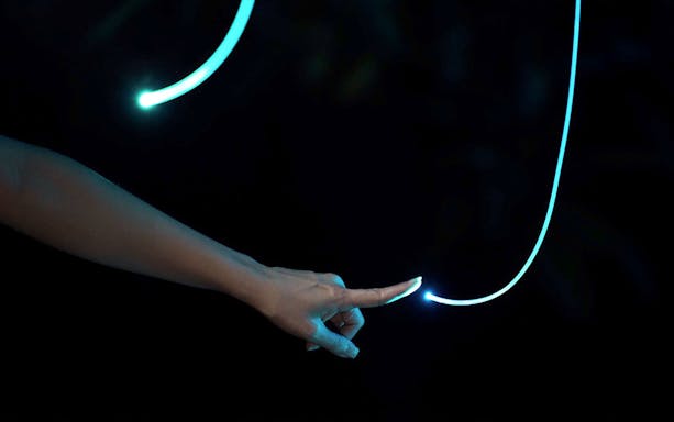 Hand touching glowing light trail in Dream Forest Langkawi.