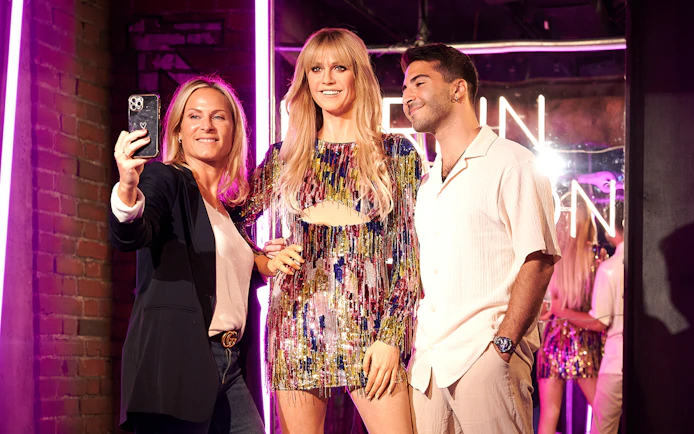 Visitors taking a selfie with a wax figure at Madame Tussauds Berlin.