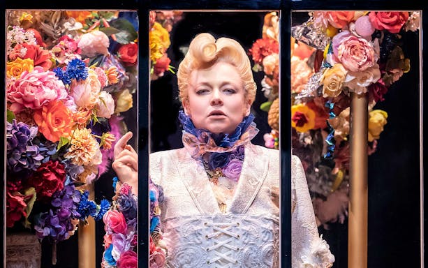 Person in ornate costume surrounded by colorful flowers, related to "The Picture of Dorian Gray.