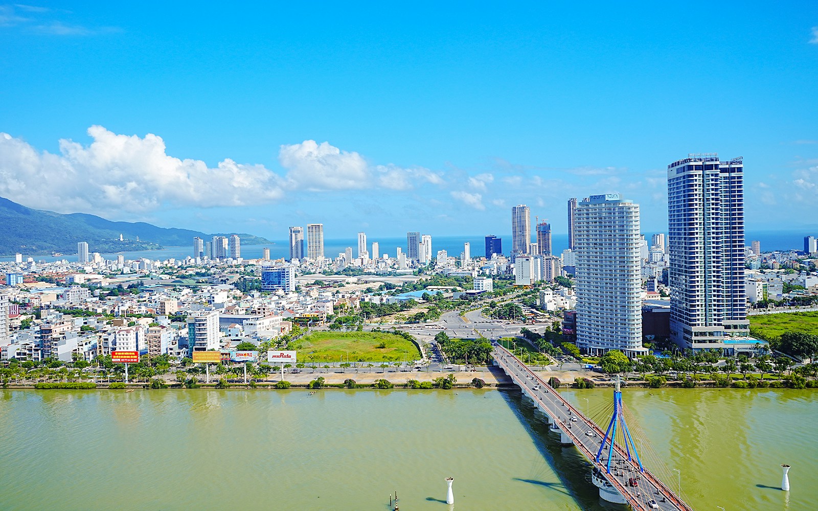 Aerial view of Da Nang cityscape with high-rise buildings and a river bridge.