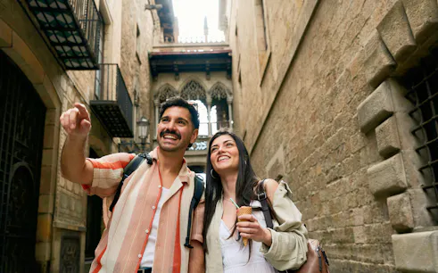 Tourists enjoying a walk in the historic Barri Gòtic street, Barcelona.