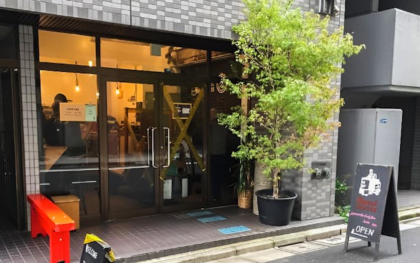 Entrance to a cafe at Tsukiji Outer Market, Tokyo, with a welcoming sign.