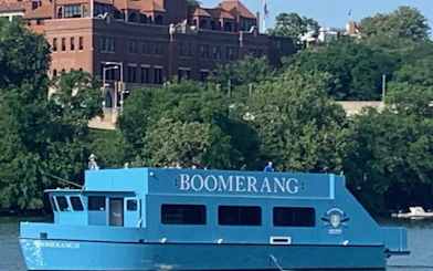 Boomerang cruise boat on Potomac River with Washington, DC landmarks in background.