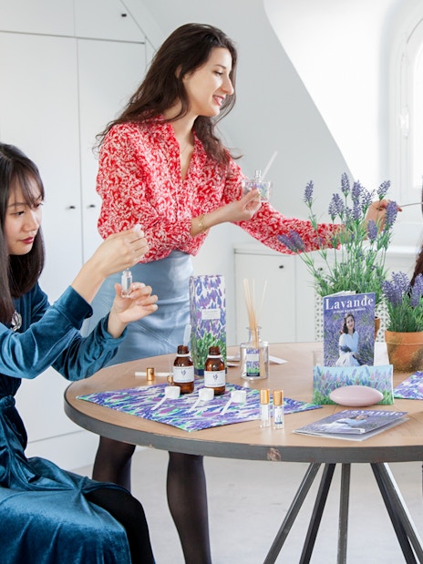 Female participants creating perfumes at a workshop in Grasse, surrounded by lavender and fragrance bottles.