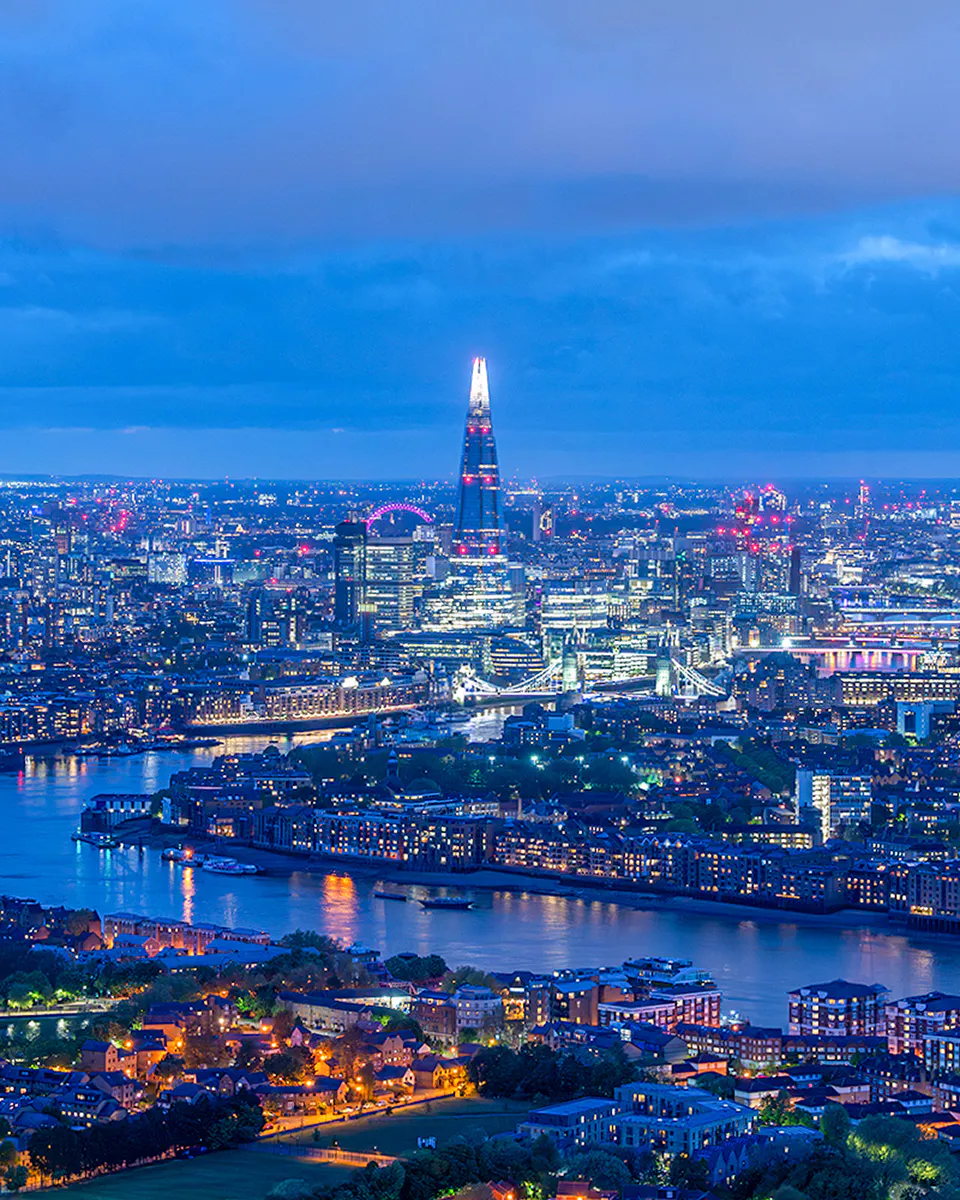 London skyline at night featuring The Shard and River Thames.