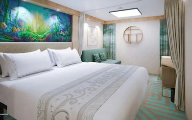 Deluxe cruise cabin with ocean-themed decor and comfortable bedding.