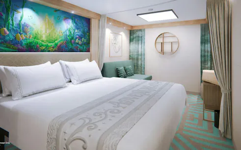 Deluxe cruise cabin with ocean-themed decor and comfortable bedding.