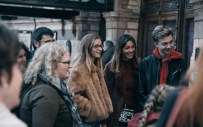 Group of tourists on York historical walking tour near Roman and Viking landmarks.